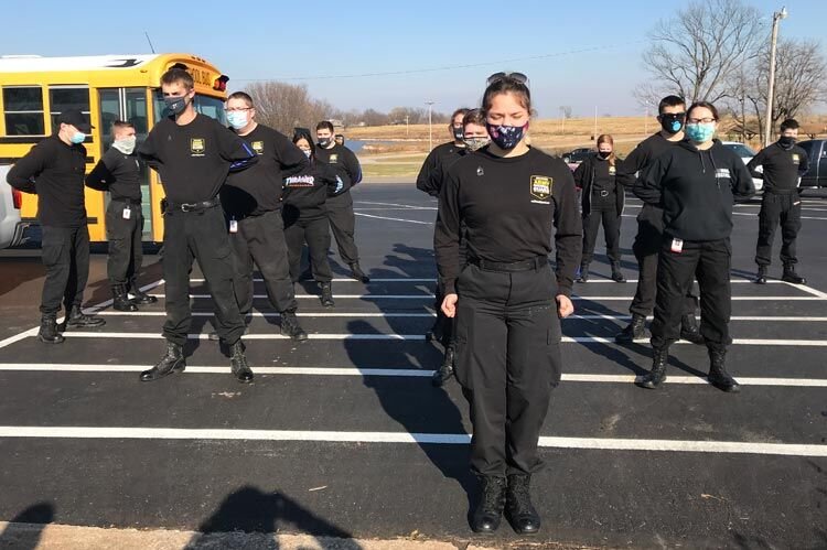 Criminal justice students from Mid-America Technology Center stand in formation Friday after arriving at the Multi-Purpose Center to assist in the distribution of food baskets and gifts provided by McClain County Operation Christmas.