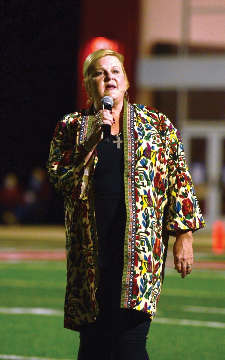 Theresa Cox sings “God Bless America” Friday night as part of the Warriors for Freedom game between Purcell and Washington.