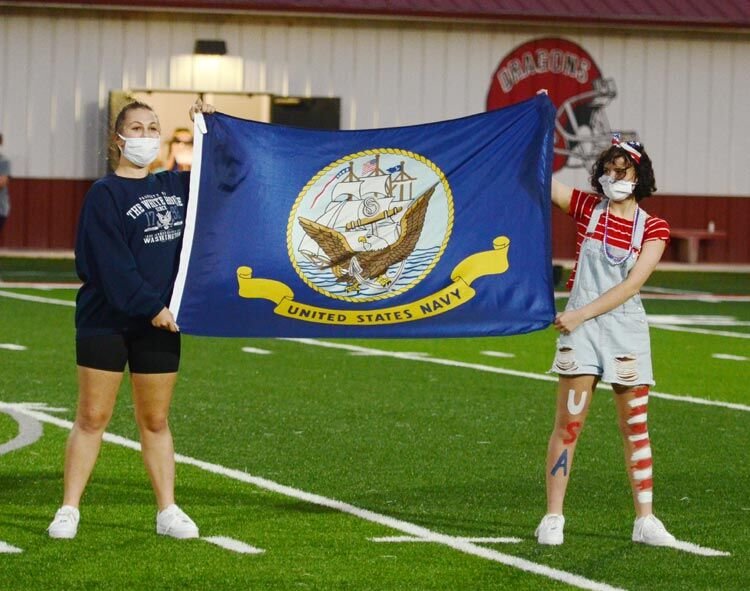 Jordan Ingram and Rosie Venegas hold the United States Navy flag while the Purcell band played the Navy march song, “Anchors Aweigh”. The band also played the march songs of the Air Force, Coast Guard, Army and Marine Corps.