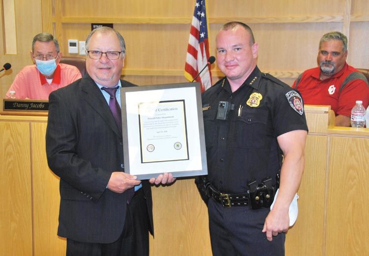 OMAG Law Enforcement Specialist Kevin McCullough, left, presented Purcell Chief of Police Bobby Elmore with a certificate officially recognizing Purcell’s Department as an Accredited Law Enforcement Agency during Monday night’s regular city council meeting.