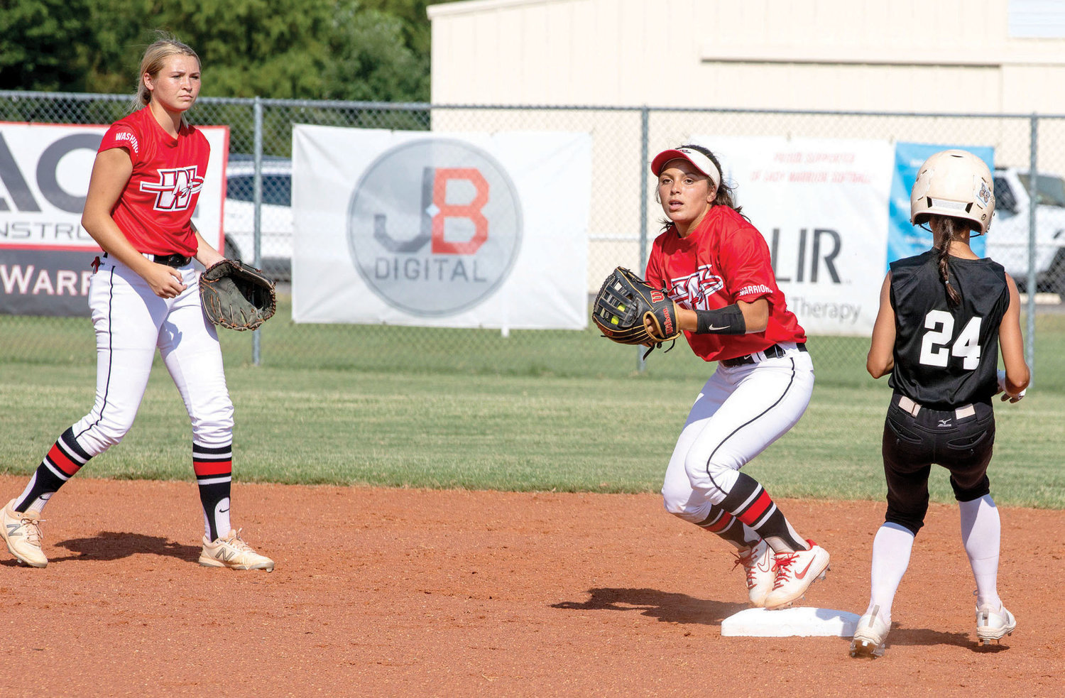 Washington senior Isa Portillo touches her base and looks to throw to first while Washington junior Skylar Wells looks on. The Warriors fell to Blanchard 6-3.