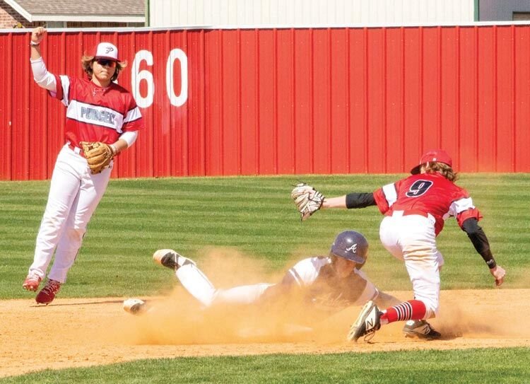 Purcell junior Hayden Harp makes the call while senior Cade Smith slaps a tag on an Asher base runner. The Dragons were defeated 14-6 by the Indians.