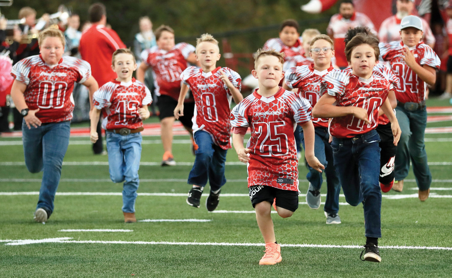 Xander Gavia (00), Collin Ellenberg (13), Jerimiah Berger (8), Cash Huff (25), Isaiah Hines, Drake Rogers (10) and Jackson Hines (34) run on the field for Purcell’s Pink Out game against Crooked Oak last Thursday night.
