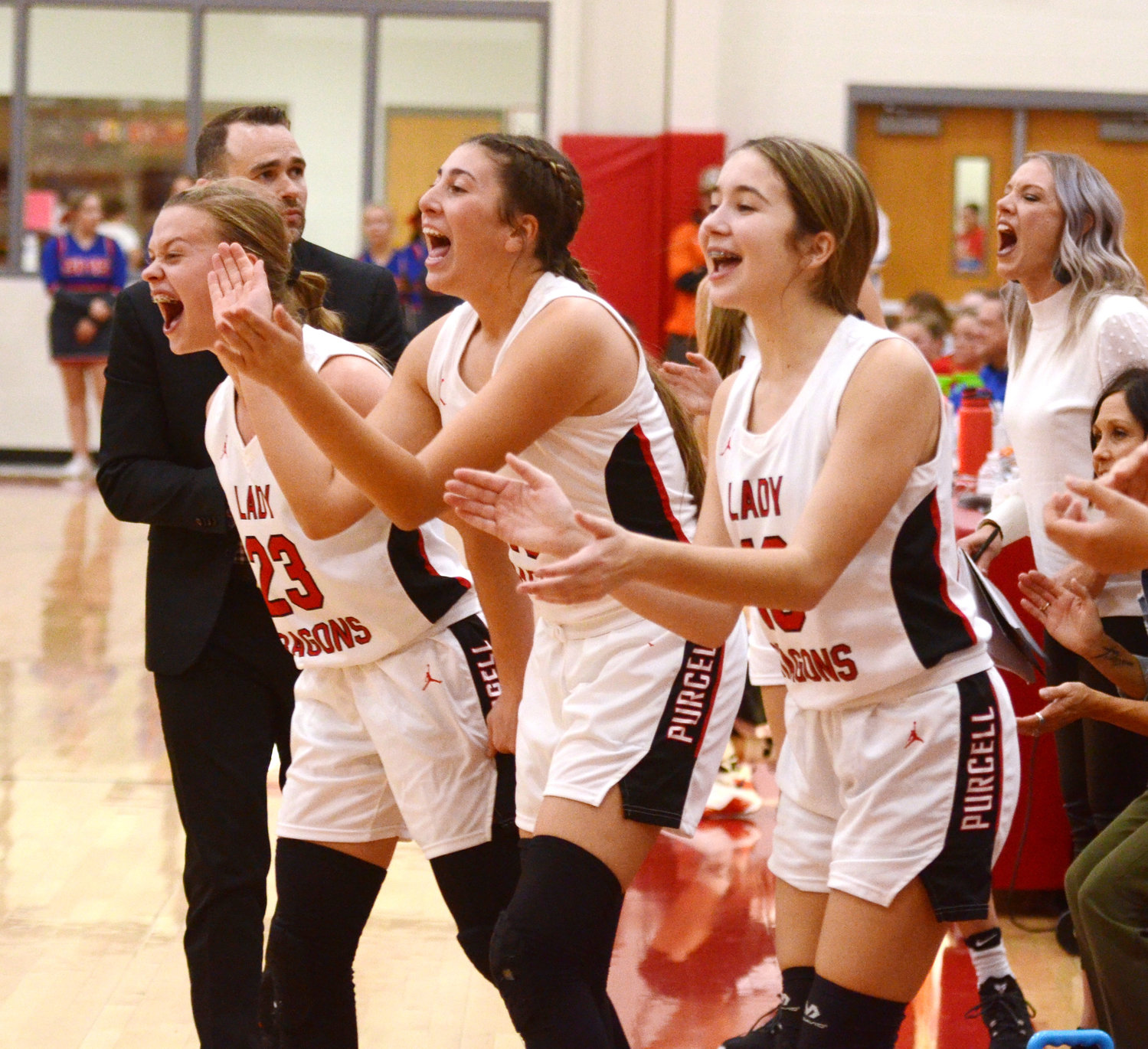 The Purcell bench erupts Friday night during Purcell’s 46-43 win over Silo. Pictured are Dragon players, from left, Hadleigh Harp, Ella Resendiz and Haven Buchanan.
