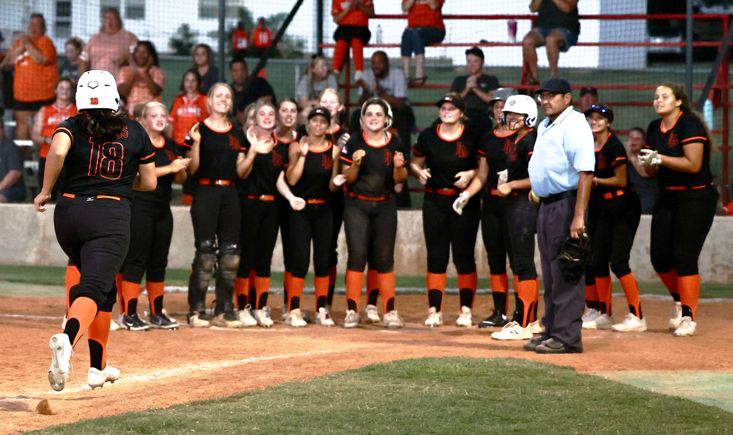 The Lexington Bulldogs wait for Cora Vasquez to cross home plate after she hit a three-run homer in the seventh inning against Purcell. The Bulldogs defeated the Dragons 8-6.