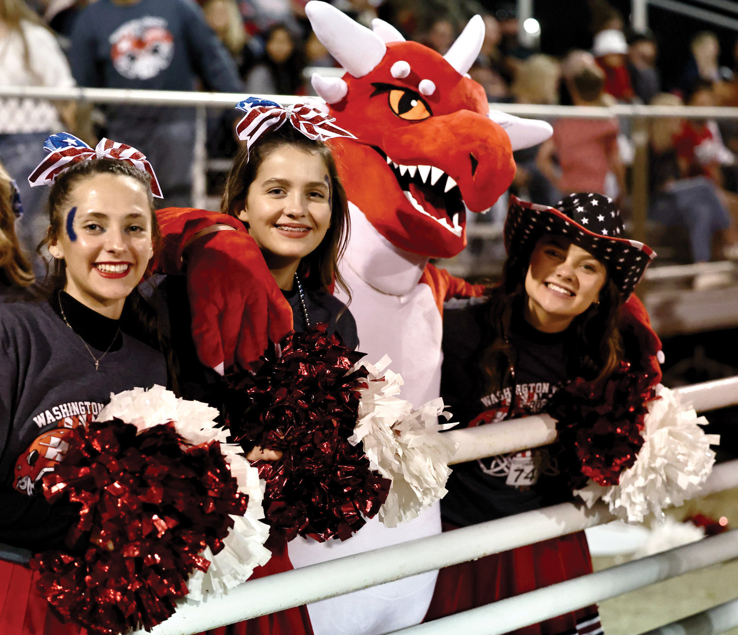 Dragon cheerleaders Marlee Spencer, Paisley Knowles, Parker Goldston in the Dragon costume and Avery Wren cheer on Purcell during the Dragons’ game against Washington Friday night.