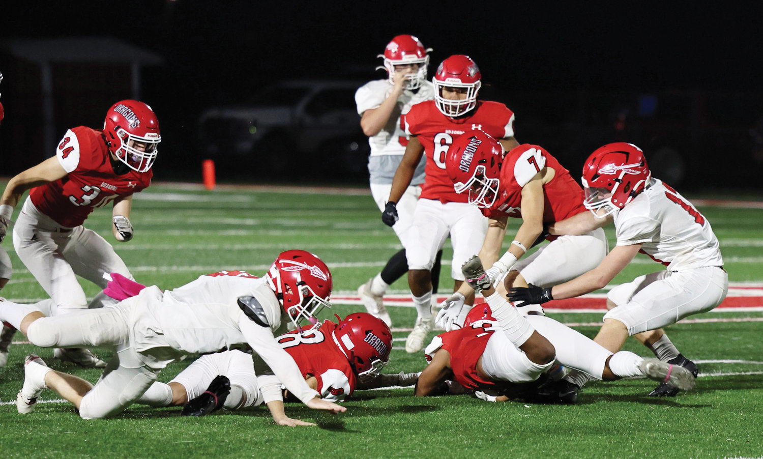 Purcell players Angel Gaytan (3), Bryan Marquez (8) and Hayden Renfro (7) scramble to recover an onside kick last Thursday during the Dragons’ 35-0 win over Comanche.