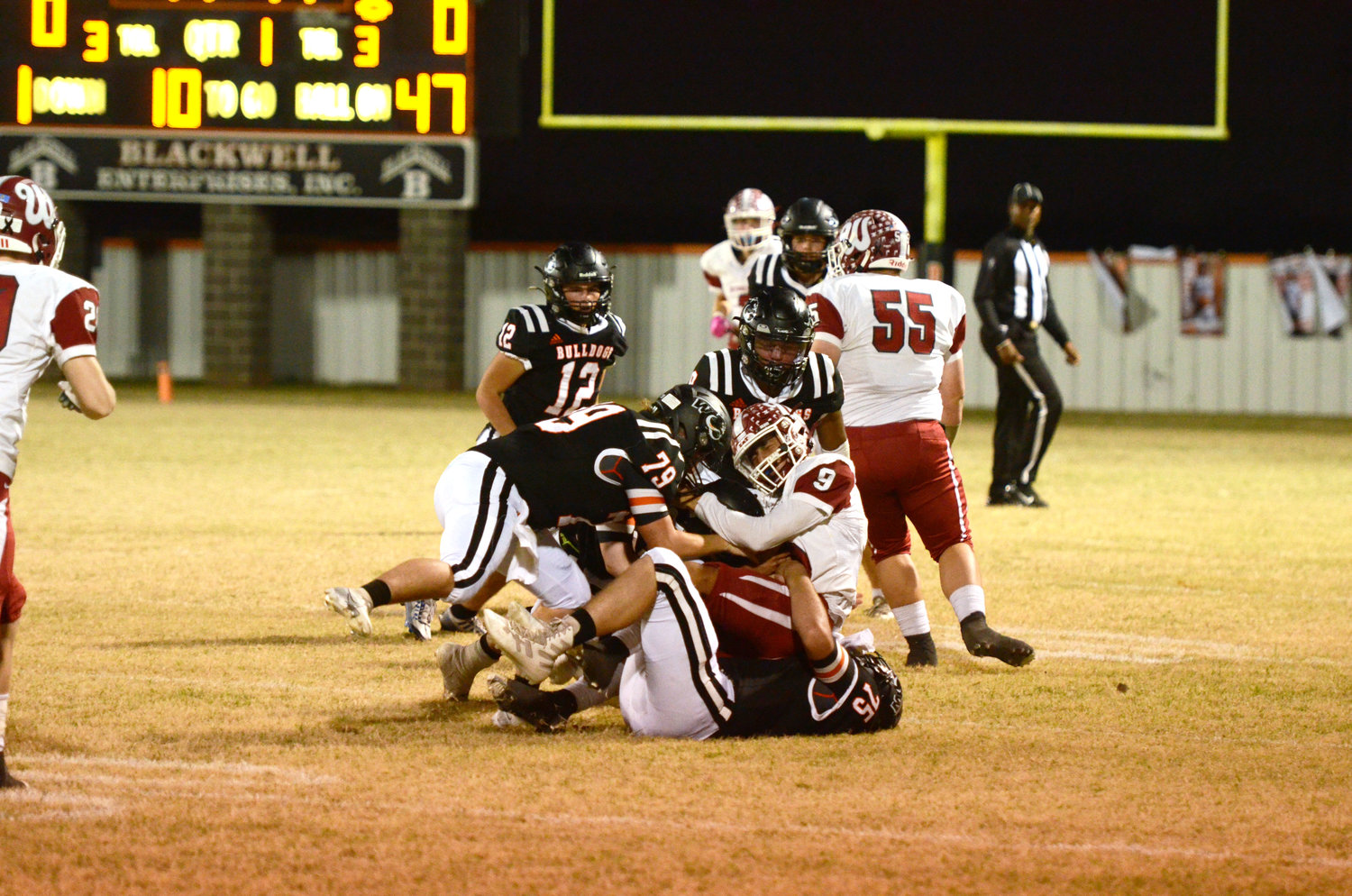 Three Wayne defenders, including Lane Jones (79), Casey Kane (75) and Taylen Bryant (9), converge on a Wynnewood ball carrier last Thursday night. Wayne’s season ended with the 35-6 loss to Wynnewood.