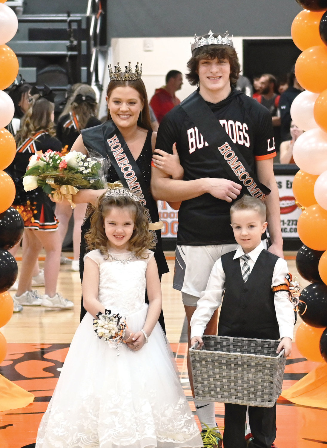 Homecoming Queen Rylee Beason locks arms with King Trey Hartzog. Also pictured are flower girl Noelanie Rollins and crown bearer Stryker Olson.
