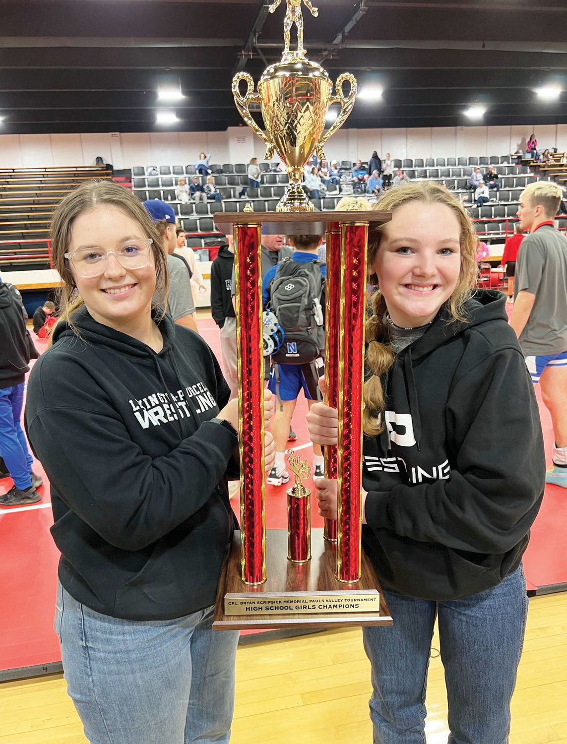 The Lexington girls were crowned tournament champions at the recent Pauls Valley wrestling tournament. From left are Bailey Forbes, Izzy Pack, Cilee Turner, Elexa Collins, Mo Collins and coach Mike McKay. Holding the trophy are Elexa and Mo.