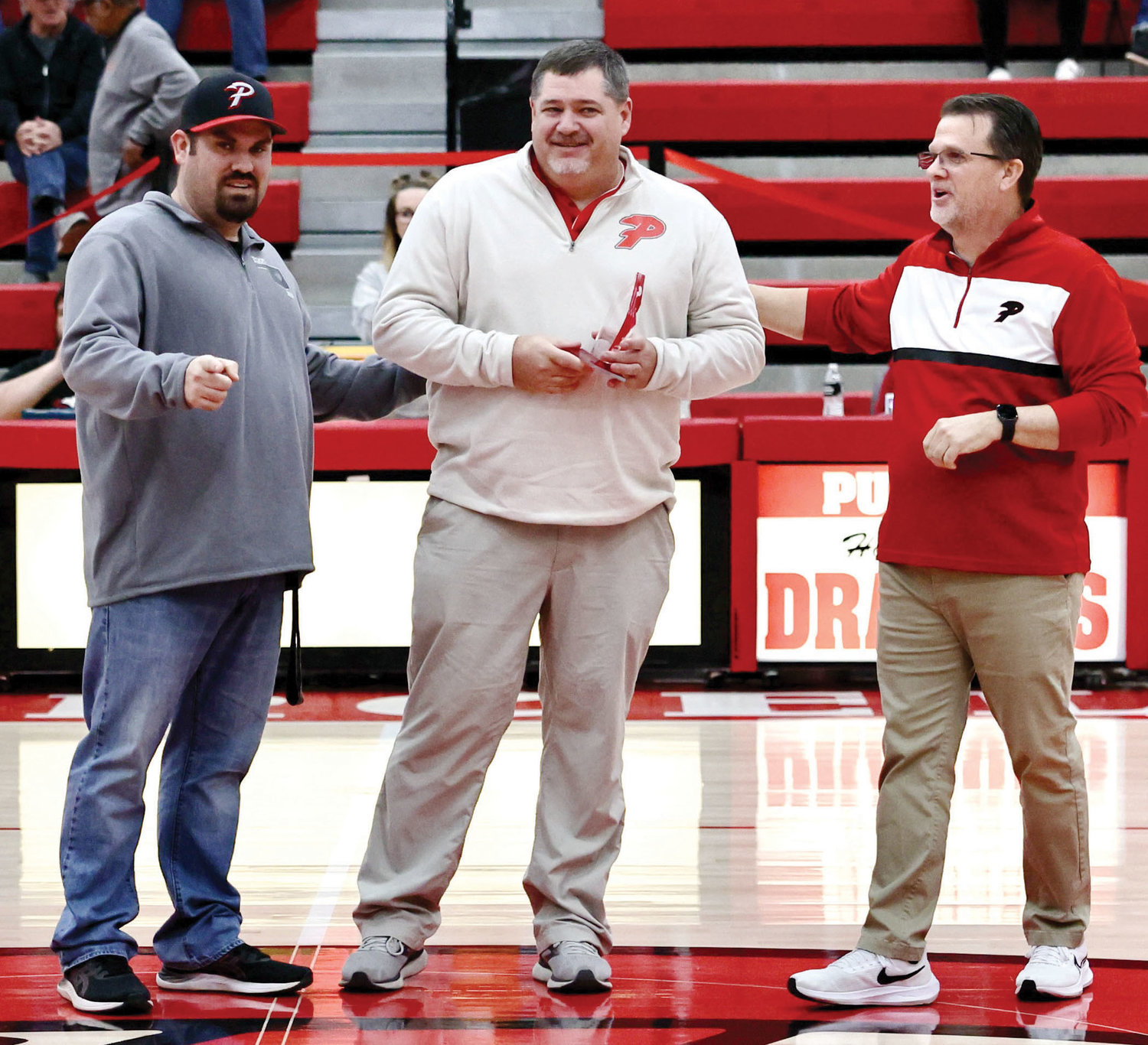 Paul Wollenberg was honored Friday night for his 26 years of coaching Purcell athletics. Wollenberg has coached basketball, softball, baseball and football at both the high school and junior high levels over his career at Purcell. Making the presentation were athletic director Ricky Hammer, left, and boy’s basketball coach Roger Raper