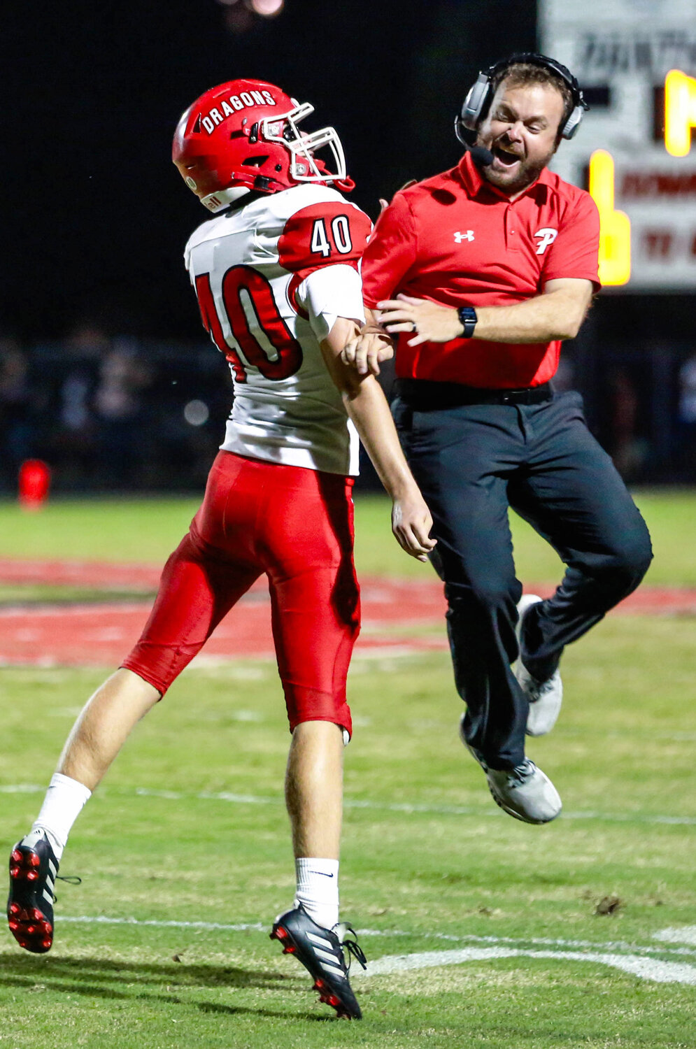 Purcell senior Noah Gracey celebrates with head coach Aaron Dillard Friday night during the Dragons’ game against Pauls Valley. Purcell was defeated 35-14.