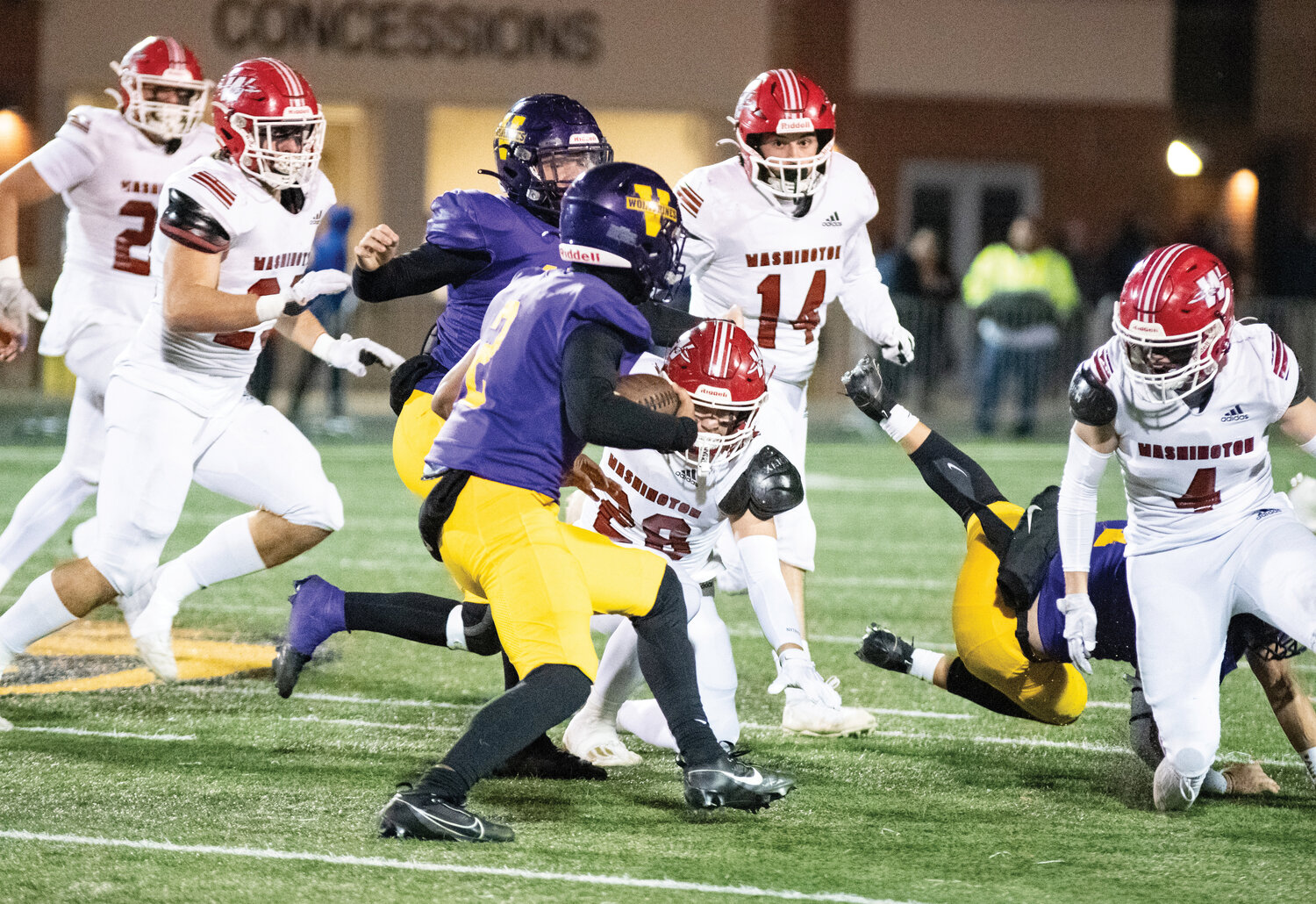 Warrior defenders Naithen Spaulding (23), Jake Coles (28), Keller Howard (14) and Cole Beller (4) bottle up a Vian ball carrier Friday night during Washington’s 47-14 playoff win. The Washington defense held Vian to 2.5 yards per rushing attempt in the game.
