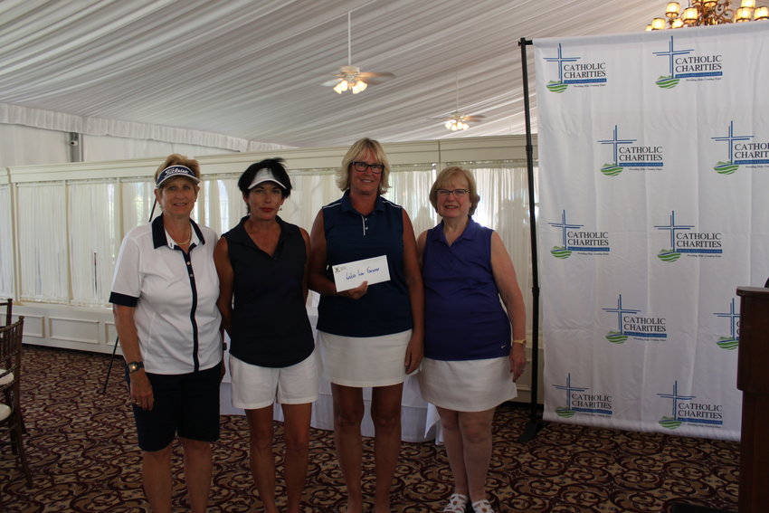 Lori Ransom, Jeannie Tomita, Denise Freeman, and Mary Bonura show off the envelope with their prize for winning first place in the women’s foursome at the Catholic Charities Golf for Charity outing.