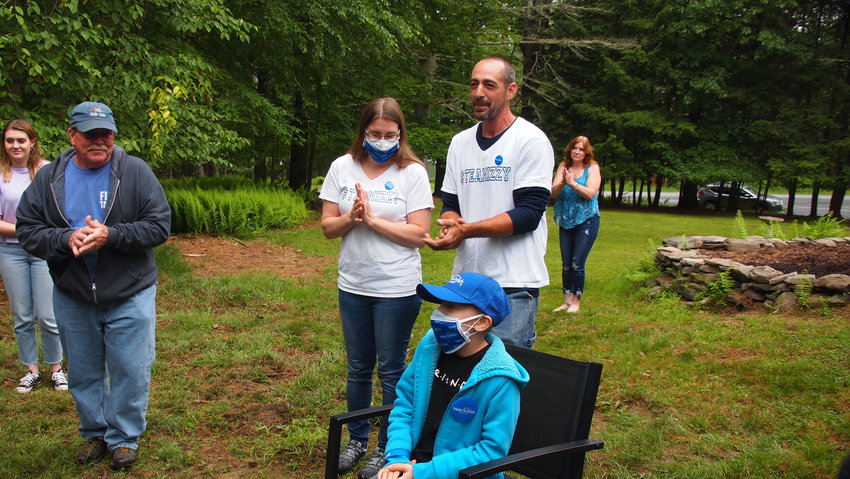 Izzy, center, waits with her parents, Terri and Daniel, to cut the ribbon and tour her new treehouse.