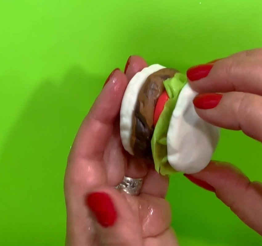 Tear off a piece of green wafer paper. Spray with Paper Potion. Scrunch it up to look like lettuce and place it on top of the tomatoes. Add the top bun.