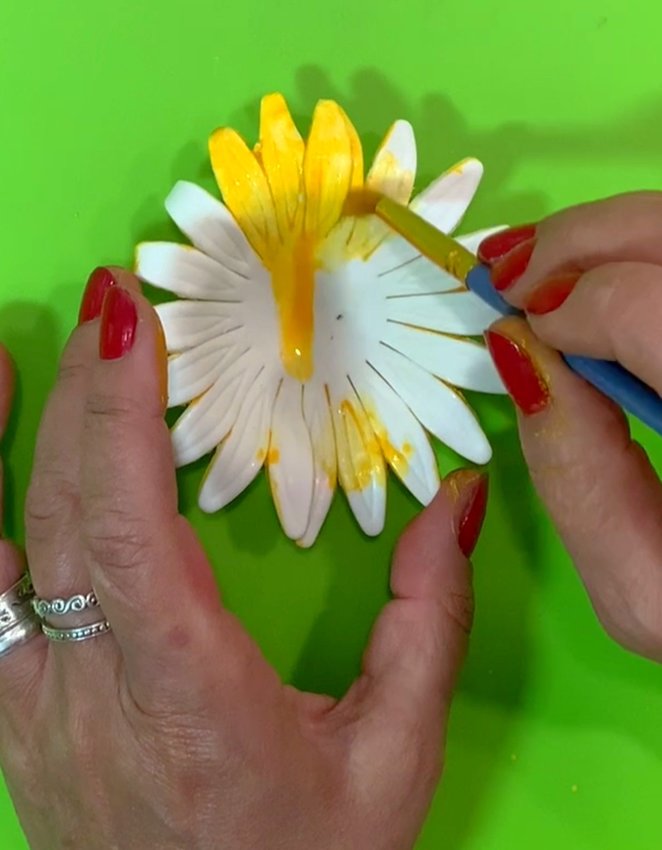 Remove the sunflower from the cup with a cake tool. Paint the sunflower with edible paint.