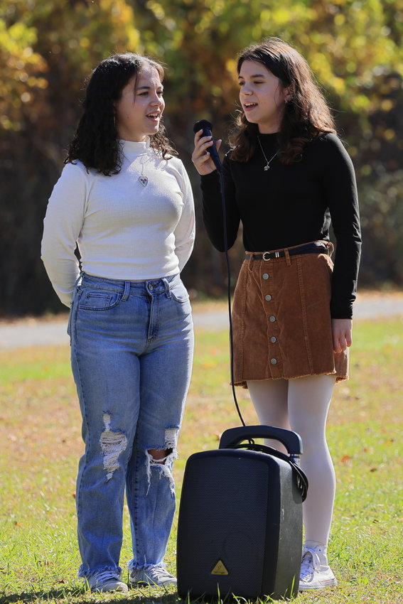 Olivia Tighe (left) and Samantha Treppeda., members of the Wallenpaupack Area High School choral group, begin the day’s game with their rendition of the national anthem in two-part harmony.
