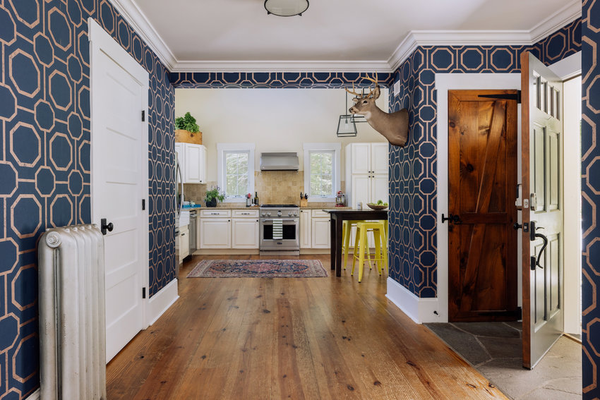 The foyer offers striking navy/white wallpaper and a knotty hardwood floor.