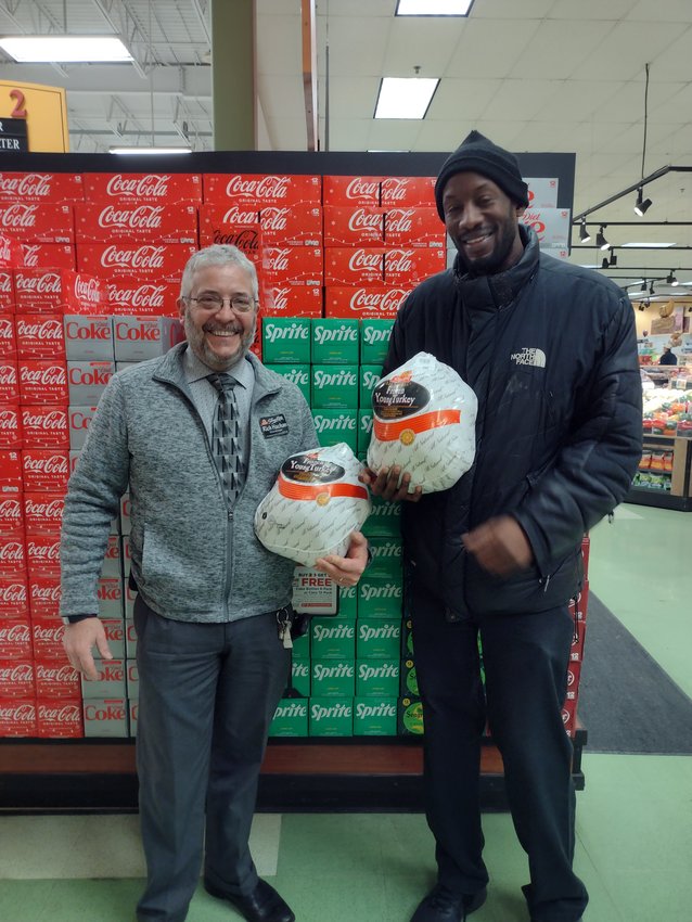 ShopRite manager Rich Hachan, left, and United Way CPO Julian Dawson hold two of the donated turkeys.  ..