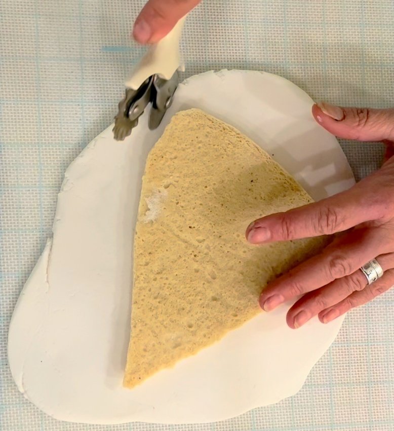 Roll out white fondant, press gently onto cookie, and trim any excess...