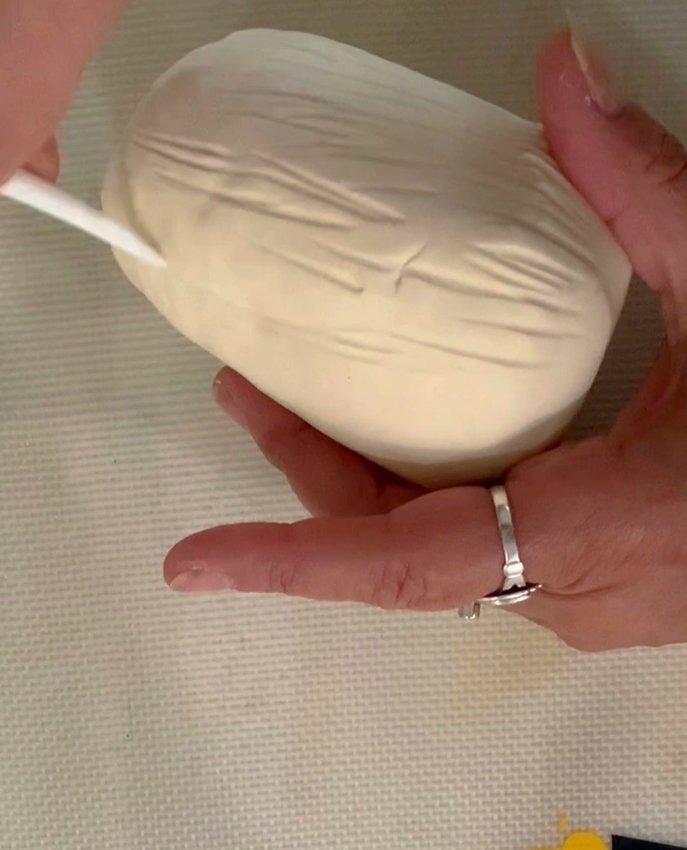 Cover the body in the fondant. Trim away the excess. Smooth with hands. Add detail ("fur") to the body with a cake tool.