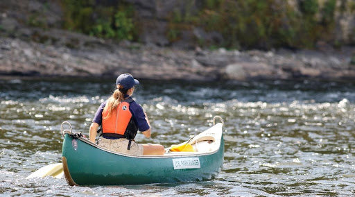 A park ranger intern canoes down the Delaware River.......