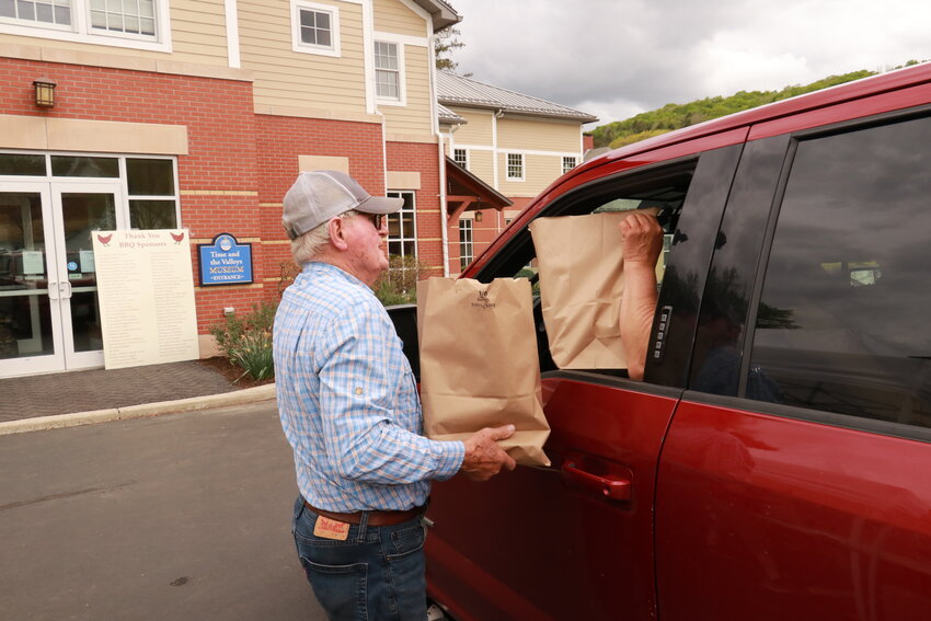 Time and the Valleys Museum president Richard Coombe brings dinners to cars at a past chicken barbcue. Proceeds support the museum.