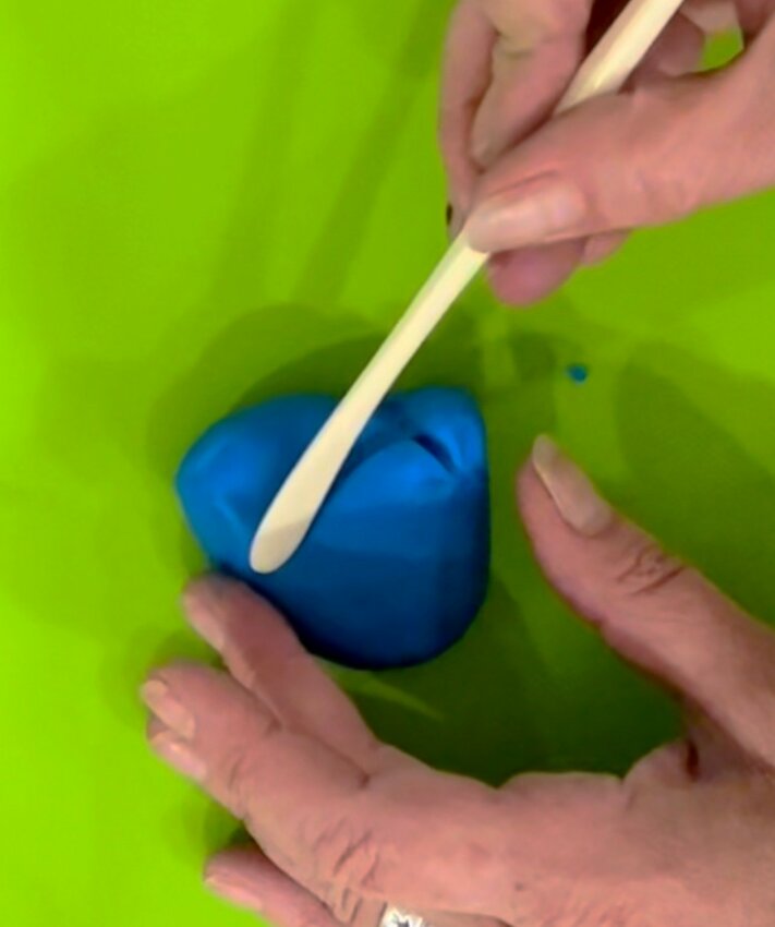 Roll a ball of blue fondant a little larger than a golf ball. Shape as desired, and use cake tool to carve out and shape arms and legs...