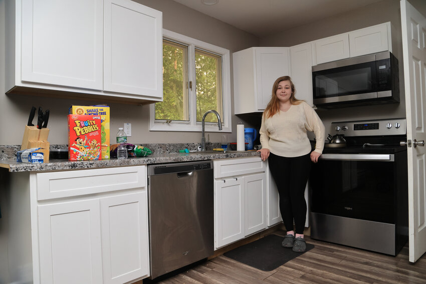 Alexis Newton standisin the kitchen that she helped to install cabinetry and countertops.