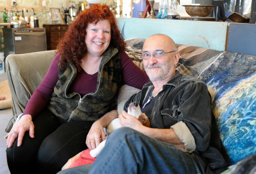 Kim and Rob Rayevsky relax in their living room with Frankie the cat...