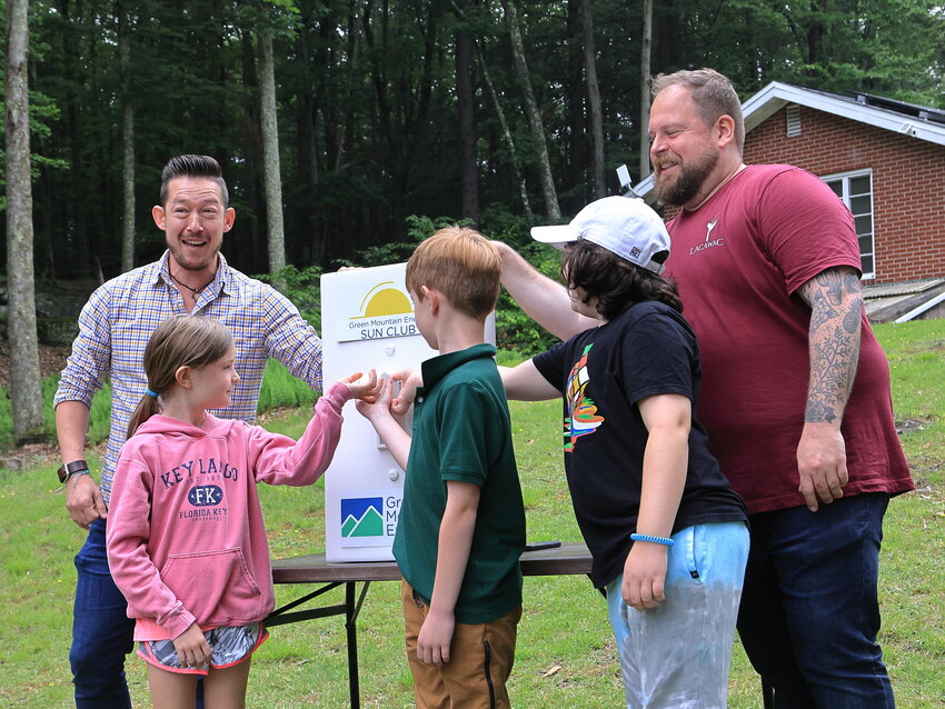 Johnny Richardson, back left, the program manager for Green Mountain Energy Sun Club; and Craig Lukatch, back right, president of Lacawac Sanctuary, were joined by three kids who were part of a group of campers staying at Lacawac. The kids flipped the ceremonial switch to turn on the solar power to the William E. Chatlos Environmental Education Center.