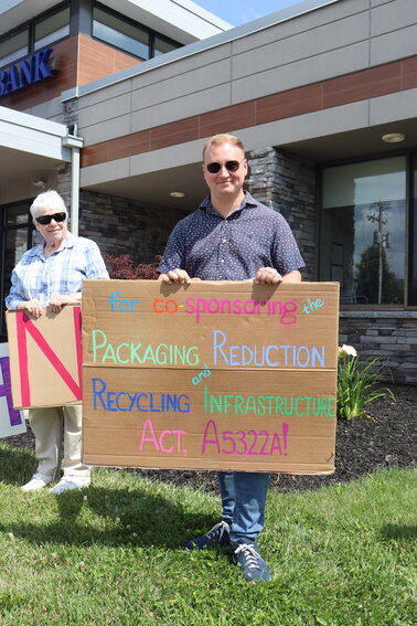 Sullivan County community member Sue Powell, left, and  legislative aid Matt McPhillips hold signs to thank Assemblywoman Aileen Gunther for her support of the packaging reduction and recycling infrastructure act.