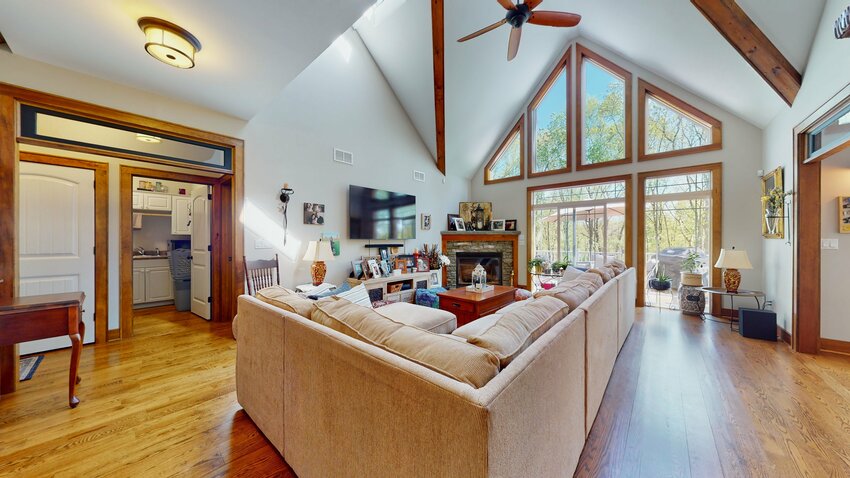 The living room offers a cathedral ceiling, a beautiful view from the quartet of windows, which follow the triangular peak of the ceiling...