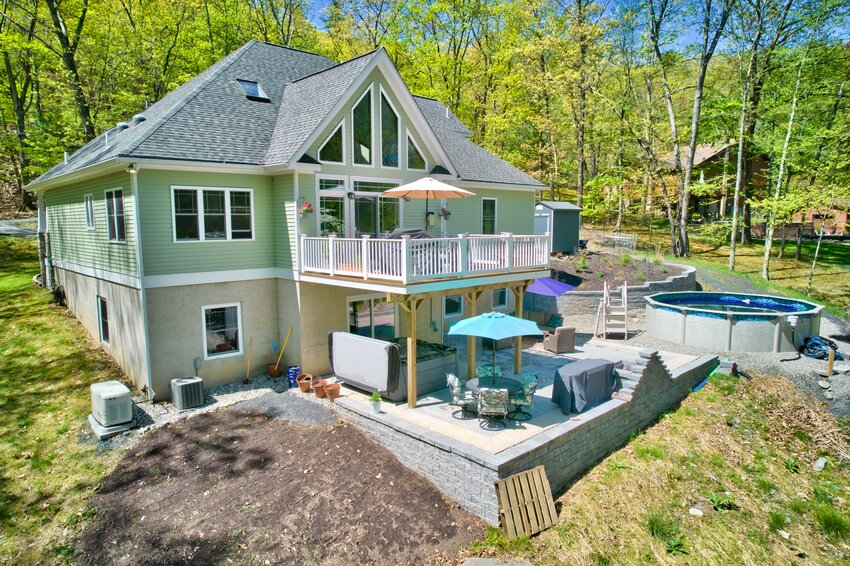 A deck and patio to relax on, plus a pool, in the backyard of the house at 143 Pond Dr.