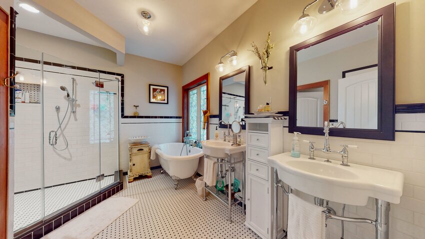 The primary suite bathroom, with the stunning shower to the left and the clawfoot tub in the back.