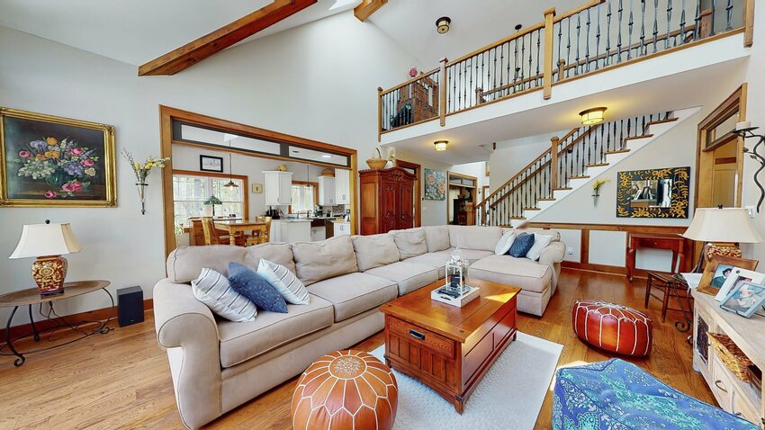 At one end of the living room is an oak-and-iron staircase and a catwalk with the same railing.