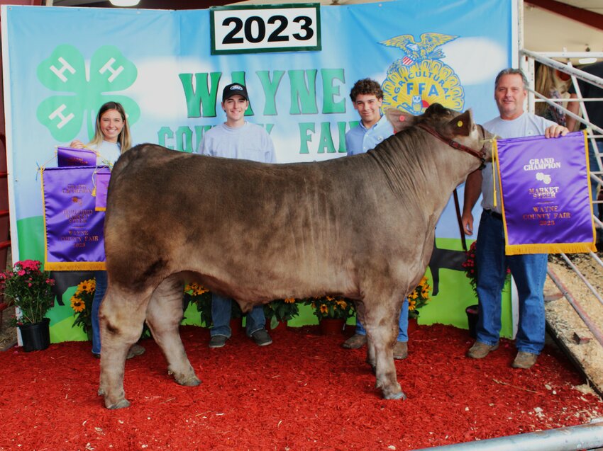Jason Vass, who exhibited the Grand Champion Market Steer, is pictured with Makayla, Matthew and John Stone for Grimm Construction...