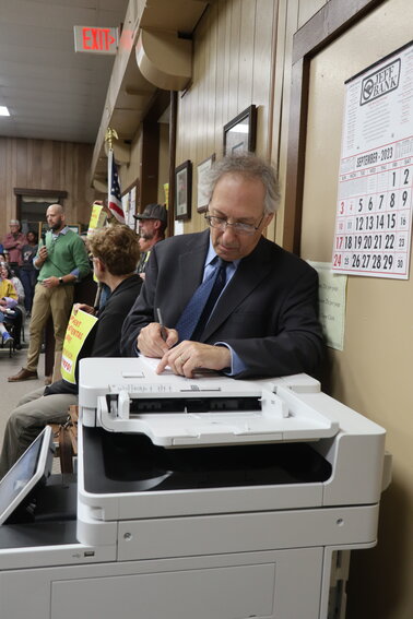 Delaware Riverkeeper lawyer Michael Sussman leans on the copier and takes notes at the September 27 Highland Planning Board meeting. The room was filled to capacity with the overflow crowd sitting on tables and standing in the back of the room.