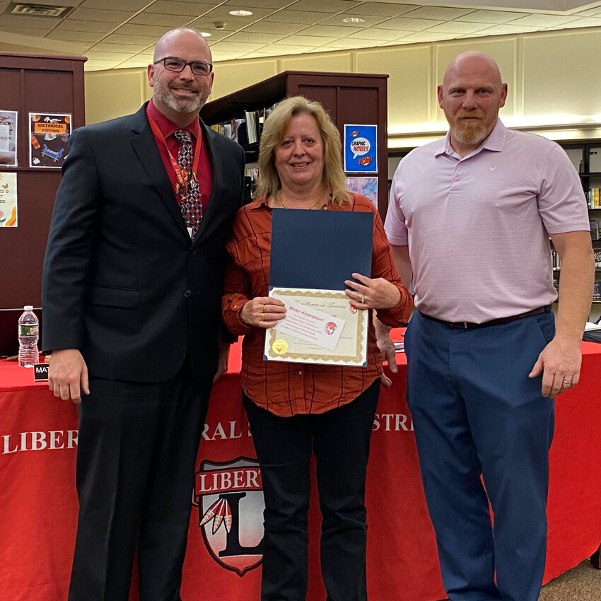 Excellence in Service Award Winner Mary Kortright poses with Superintendent Dr. Patrick Sullivan, left and Board President Matthew DeWitt, right.