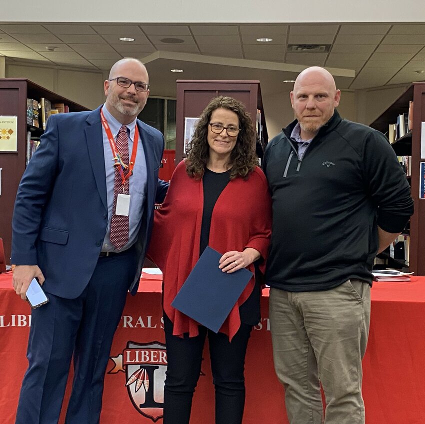 Mary Bayer is pictured center with Liberty superintendent Dr. Patrick Sullivan, left, and school board president Matthew DeWitt.