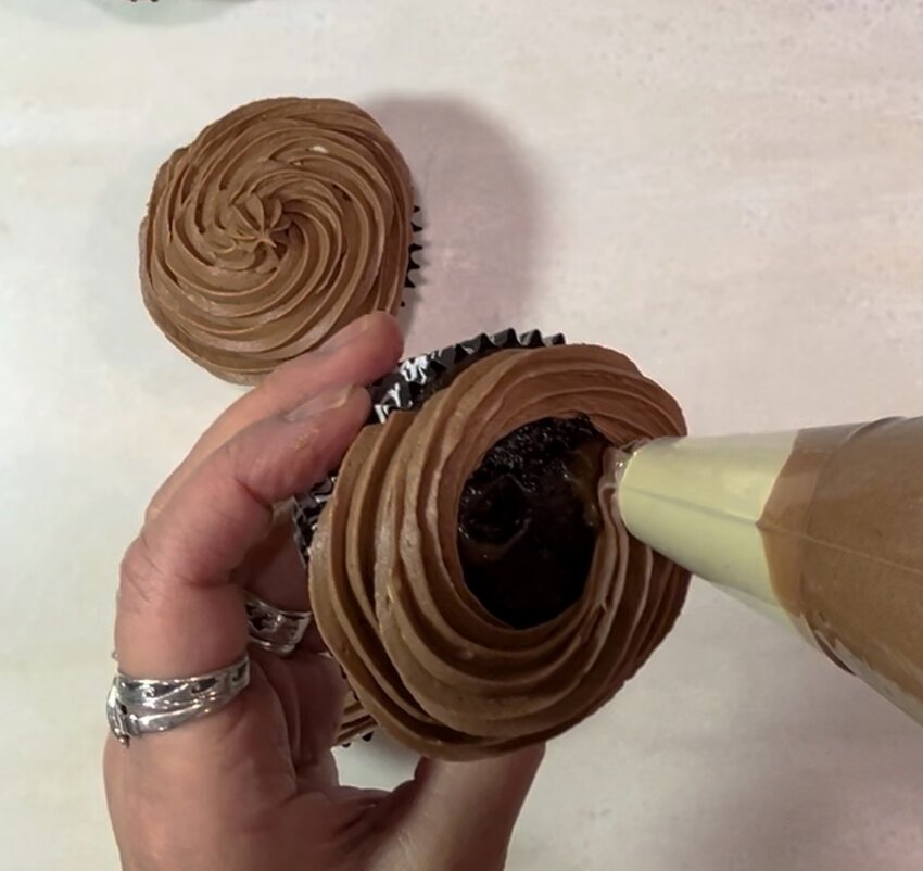 Use a piping bag filled with stout buttercream and a decorative tip to decorate the cupcakes.