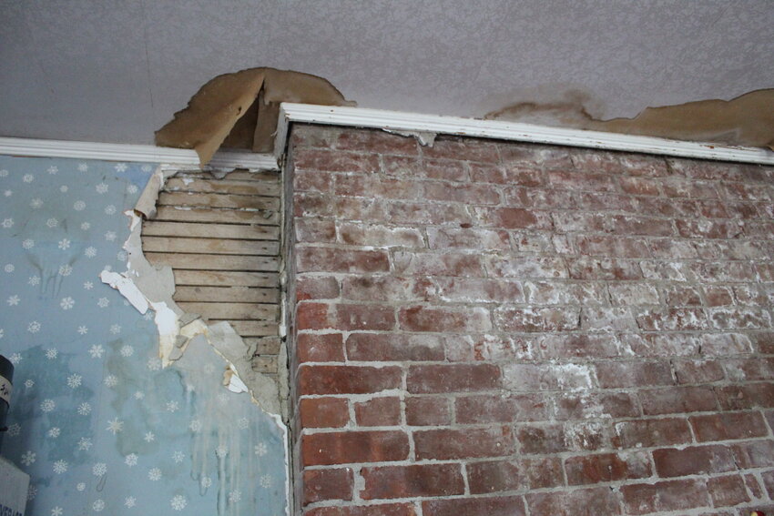 A closeup of damage around a chimney. We assume it was a leak. The flashing got fixed but this mess needs to be repaired.