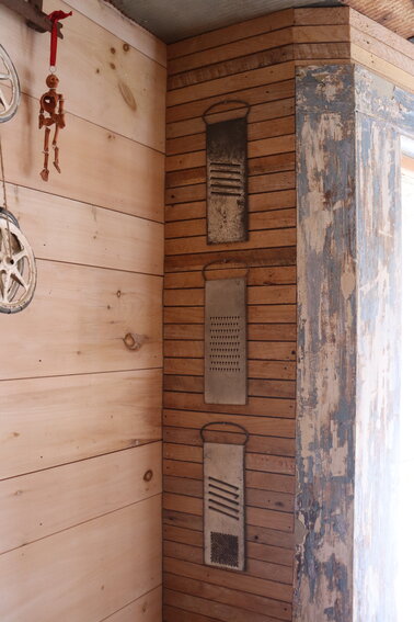 Some of the objects used in Roth's home renovation barely needed any changes before they made it into the build—like these cheese graters, hung in a column on one of the living room walls. "They're beautiful, right? They're just like little works of art," Roth says.