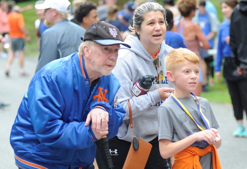 At the finish line. Nine-year-old Bradley Kenney, a third-grader at  Tri-Valley,  took first place in the male 10 and under category, and completed the race 69th overall with a time of 24:10. He is pictured with Edward Kenney, left, the young runner&rsquo;s grandfather; and his mom Michelle.