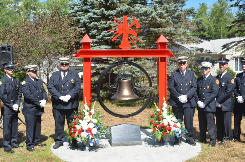 The memorial in honor of William &quot;Billy&quot; Steinberg stands in place outside the Forestburgh Fire Company No. 1 building, flanked by firefighters.