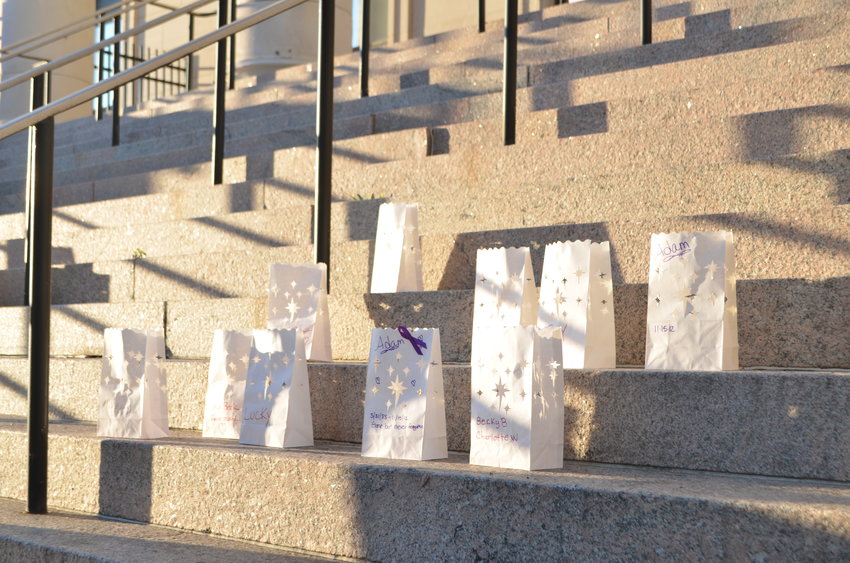 Paper bags lit from the inside list the names of those lost to overdoses.