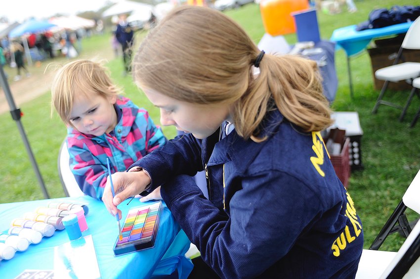 The face of the FFA. Alison McCarthy, a Sullivan West seventh-grader, is shown painting the face of a young attendee at the Diehl Homestead Farm&rsquo;s first Fall Festival, held on October 8.