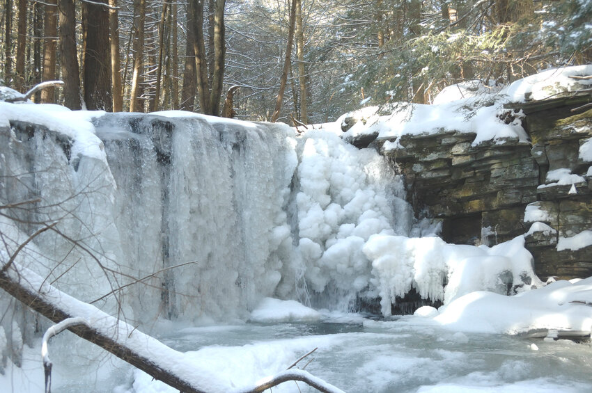 During a cold spell a few years ago, low temperatures hit sub-zero levels for close to a week before this photo was taken. The result is what appears to be a frozen waterfall. In reality, water is flowing under the vertical part of the ice sculpture underneath the ice just below the falls (which makes it unsafe to walk on). Moving water, such as a stream or waterfall, takes lower temperatures and longer times to freeze compared to still water, such as lakes and ponds...