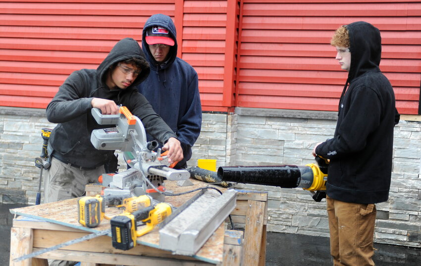 Sullivan BOCES students Juan Rivera from Liberty High School and Ellenville High School students Patrick Nolan and Tyler Dumas are pictured as they complete the stone facia of Station 40.